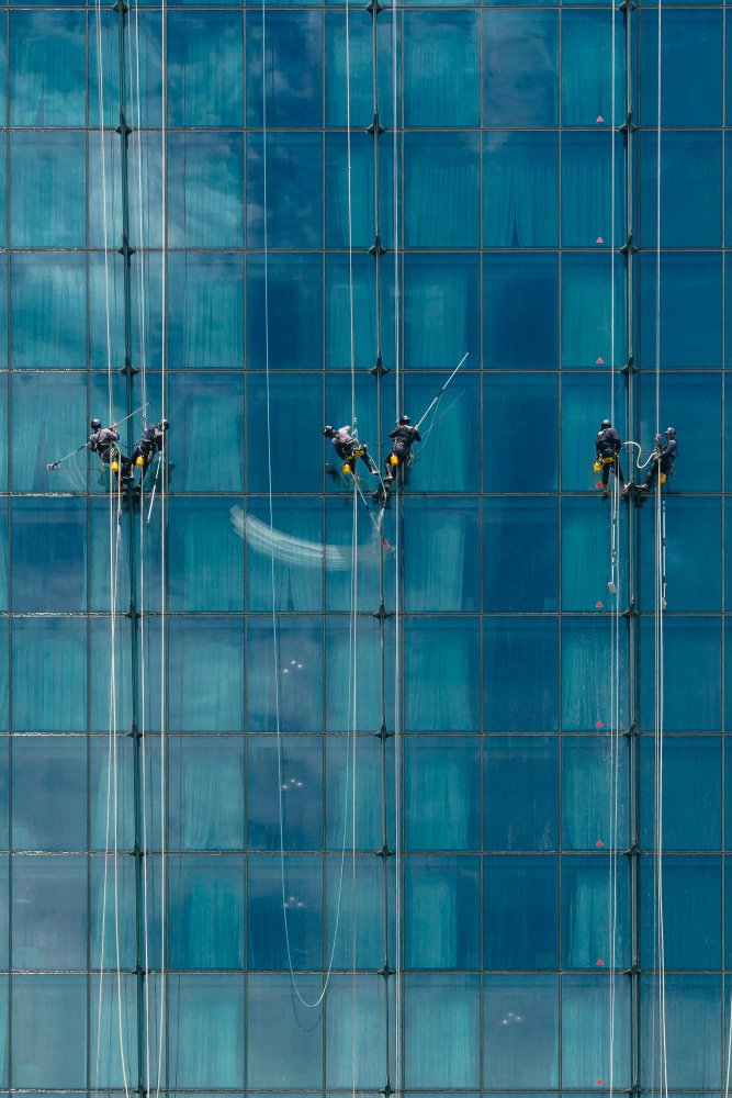full-frame-shot-workers-windows-against-building