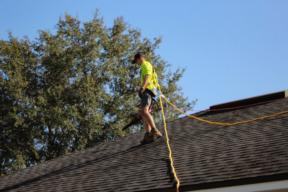 A cleaner on a roof with a pipe